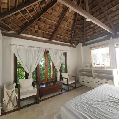 a bedroom with a bed and a desk and windows at The Hip House Villa Phuket in Ban Bang Khu