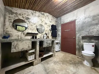a bathroom with a sink and a toilet and a mirror at Jungle house at Yanui beach in Rawai in Phuket Town