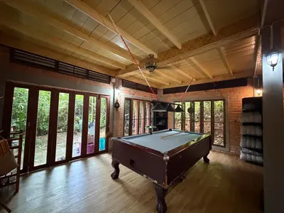 a pool table in a room with windows at Jungle house at Yanui beach in Rawai in Phuket Town