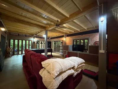 a living room with a red couch and a tv at Jungle house at Yanui beach in Rawai in Phuket Town