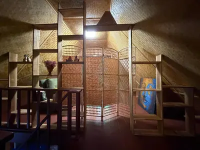 a room with a staircase and a wall with shelves at Jungle house at Yanui beach in Rawai in Phuket Town