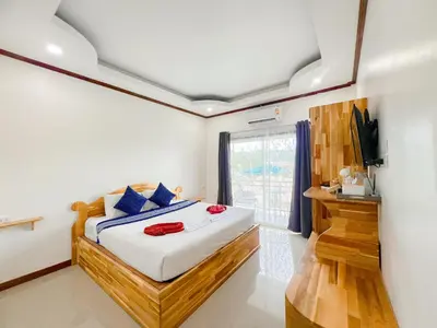a bedroom with a bed and a tv and a window at La Depa PP House in Phi Phi Don