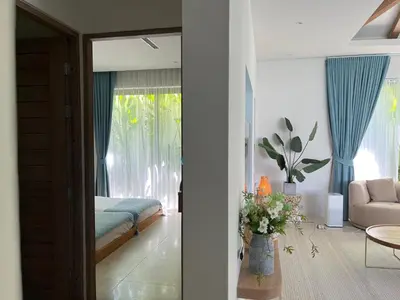 a living room with a bed and a table with flowers at 3 Bed Bang Tao pool villa at The Lux in Phuket Town