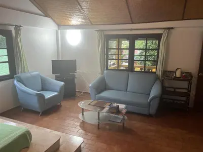a living room with two blue couches and a coffee table at Baan Orchid Guesthouse in Patong Beach