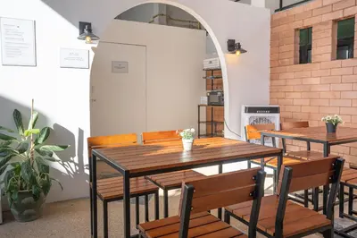 two tables and chairs in a room with a plant at Baan Old Town Boutique Stay, Phuket Town in Phuket Town
