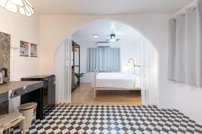 a bedroom with a bed and a checkered floor at Baan Old Town Boutique Stay, Phuket Town in Phuket Town