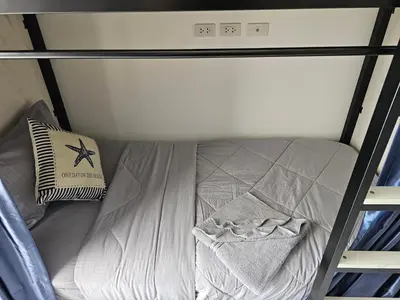 a small bed in a small room with an alarm clock at Haru Inn Airport in Ban Bo Han