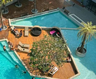 an overhead view of a swimming pool with a palm tree at Citygate Kamala Resort & Residence in Kamala Beach