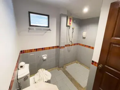 a bathroom with a toilet and a shower at Ongsantiphap villa resort in Ban Klang