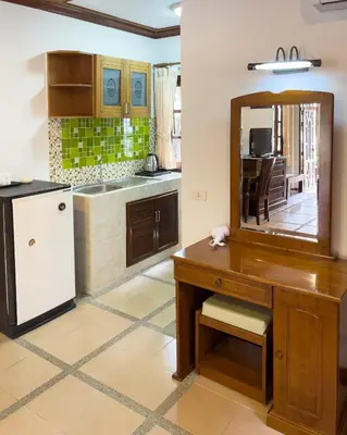 a kitchen with a wooden desk and a mirror at Ongsantiphap villa resort in Ban Klang