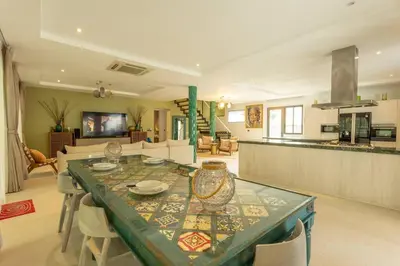 a kitchen and living room with a table and chairs at Brand new, designer furnishing, hot tub, gym, pool V98 in Rawai Beach