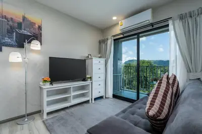 a living room with a couch and a large window at A1 The Title Nayang Стильная квартира in Nai Yang Beach