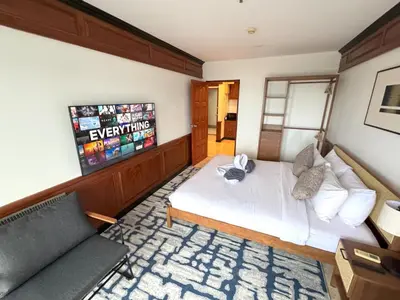 a bedroom with a bed and a couch and a television at Sea view apartment with jacuzzi at Patong Tower in Patong Beach
