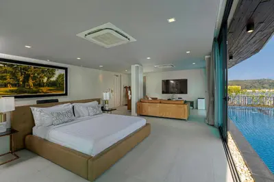 a bedroom with a large bed and a swimming pool at Villa W Luxury in Nai Harn Beach