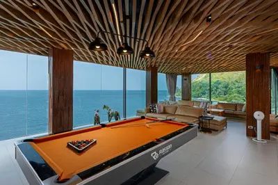 a pool table in a living room with a view of the ocean at Villa W Luxury in Nai Harn Beach