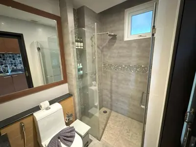a bathroom with a glass shower and a toilet at Spacious mountain view studio at Sea Sky 206 in Karon Beach