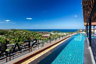 a swimming pool on the balcony of a building with the ocean at Spacious mountain view studio at Sea Sky 206 in Karon Beach