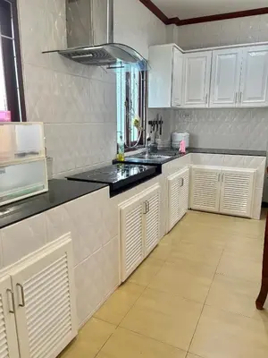 a kitchen with white cabinets and a sink at Amazing 4BR pool villa near beach Bangtao in Ban Thalat Choeng Thale