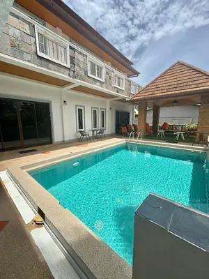 a swimming pool in front of a house at Amazing 4BR pool villa near beach Bangtao in Ban Thalat Choeng Thale