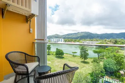 a balcony with two chairs and a view of the water at Lakeside Residences by NLA in Bang Tao Beach