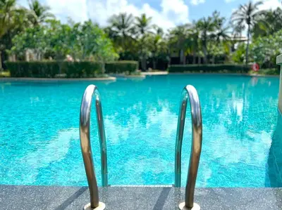a pair of metal chairs by a swimming pool at Laguna Village by RESAVA in Layan Beach