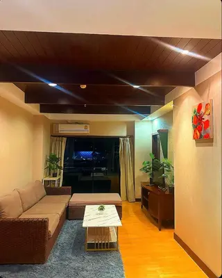 a living room with a couch and a table at Patong Tower Apartments By Tida in Patong Beach