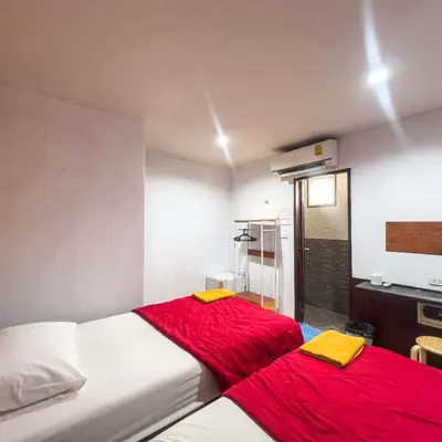 a bedroom with two beds with red sheets at Happy House in Phi Phi Don