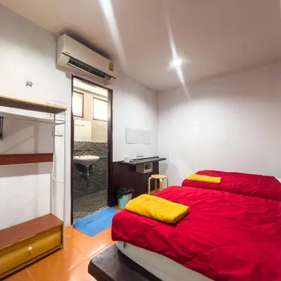a bedroom with a red bed and a sink at Happy House in Phi Phi Don