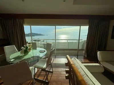 a dining room with a table and chairs and a large window at Patong Tower apartment with a great view in Patong Beach