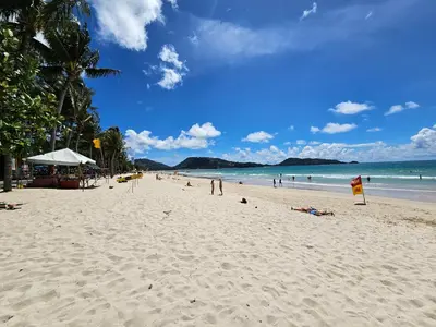 a beach with people on the sand and the ocean at Patong Tower apartment with a great view in Patong Beach