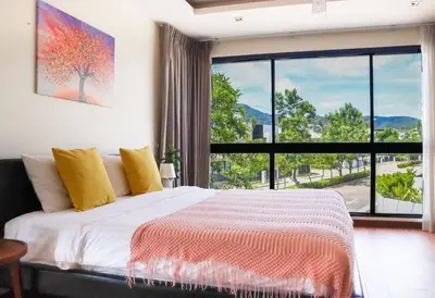 a bedroom with a bed and a large window at Big Garden Townhouse Laguna Park in Phuket Town