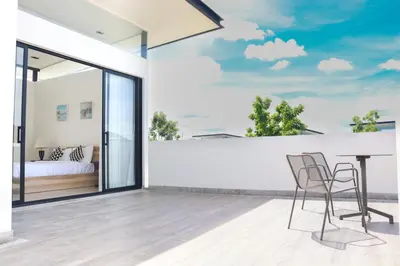 a bedroom with a balcony with a table and chairs at Big Garden Townhouse Laguna Park in Phuket Town