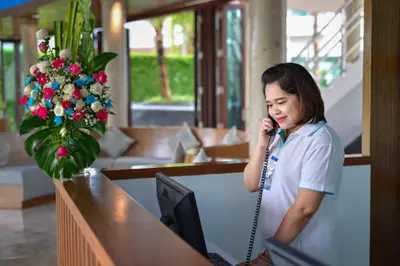 a girl talking on a cell phone in a lobby at Fishermens Harbour Urban Resort - SHA Extra Plus in Patong Beach