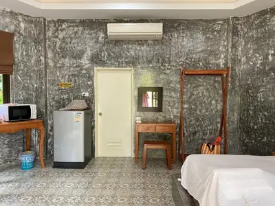 a room with a refrigerator and a bedroom with a bed at Green Tree Cottage 1 in Klong Muang Beach