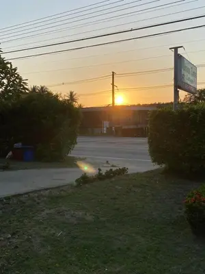 a sunset in a parking lot with a sign at Green Tree Cottage 2 in Klong Muang Beach
