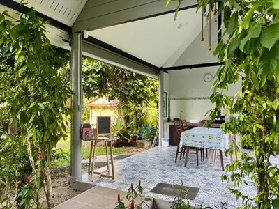 a covered patio with a table and chairs at Moonlight Cottage in Ban Pa Khlok