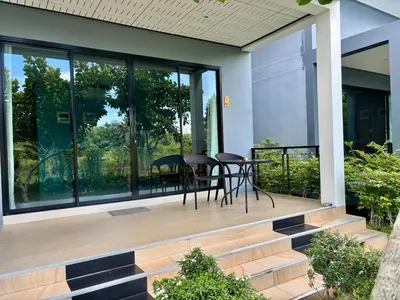 a porch with a table and chairs on it at Moonlight Cottage in Ban Pa Khlok