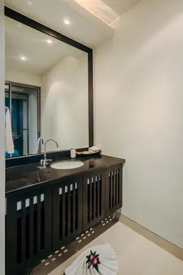 a bathroom with a sink and a large mirror at Luxury Penthouse Apartment 8C at Kata Gardens in Kata Beach