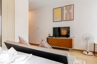 a bedroom with a bed and a flat screen tv at The Proud Rawai Studio in Phuket Town