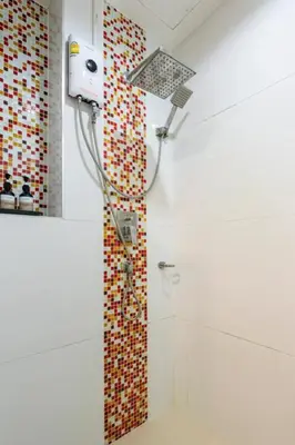 a shower in a bathroom with a mosaic wall at The Pixels Cape Panwa Condo in Ban Ao Makham