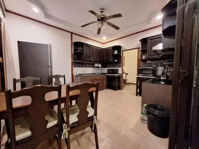 a kitchen with a table and a ceiling fan at Garden & private pool house in Surin Beach