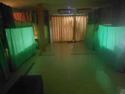 an empty room with green curtains and a tiled floor at Lucky Dorm in Phi Phi Don
