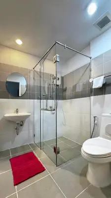 a bathroom with a shower and a toilet and a sink at Vi Stay in Phuket Town