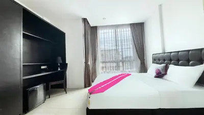a bedroom with a large bed and a large window at Vi Stay in Phuket Town