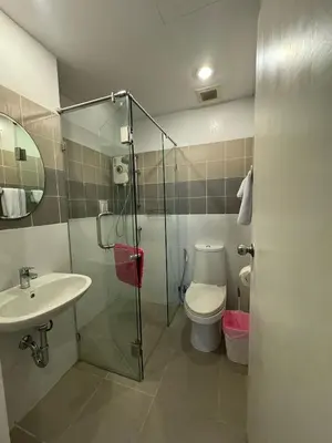 a bathroom with a shower and a toilet and a sink at Vi Stay in Phuket Town