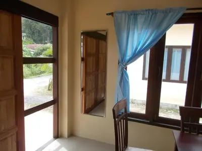 a room with two windows and a blue curtain at Absolute calm for long sleepers and others in Kamala Beach