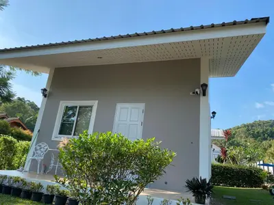 a white house with a window and a porch at Green Tree Cottage 4 in Klong Muang Beach