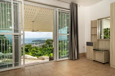 a room with large sliding glass doors with a view at Villa Olympus Ocean Vista Kata Beach in Kata Beach