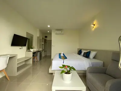 a hotel room with a bed and a couch at Puean Chang Resort Phuket in Thalang
