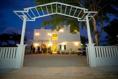 a group of people standing outside of a house at night at Puean Chang Resort Phuket in Thalang